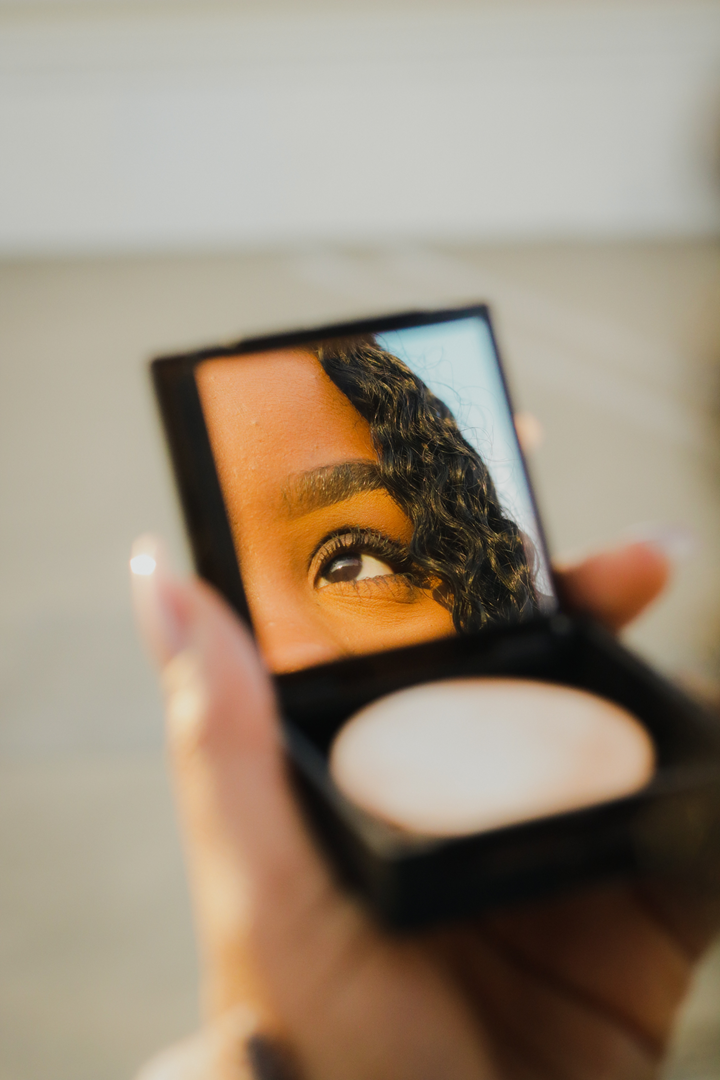 Woman looking into compact mirror