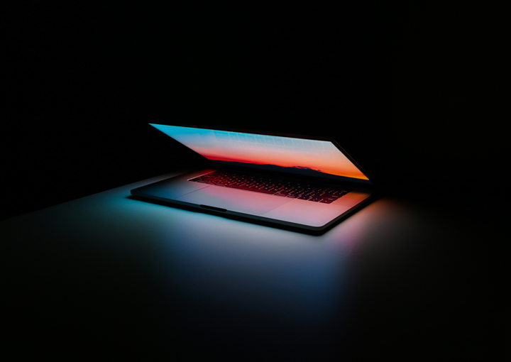 A laptop on a table that is glowing in the dark