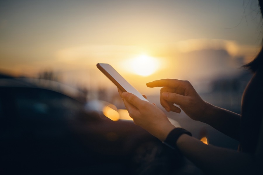 Woman using smartphone at sunset